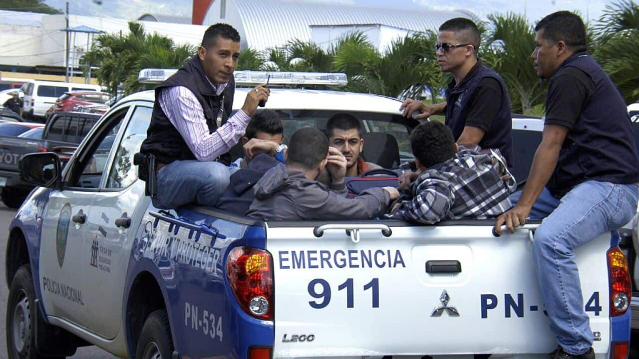 Honduran policemen escort five of the six Syrian citizens arrested at the Tocontin international airport in Tegucigalpa.