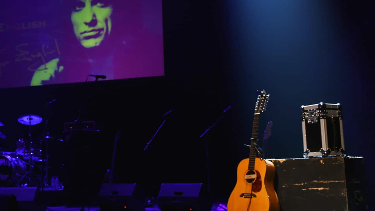 An image of singer Jon English is projected onto a screen