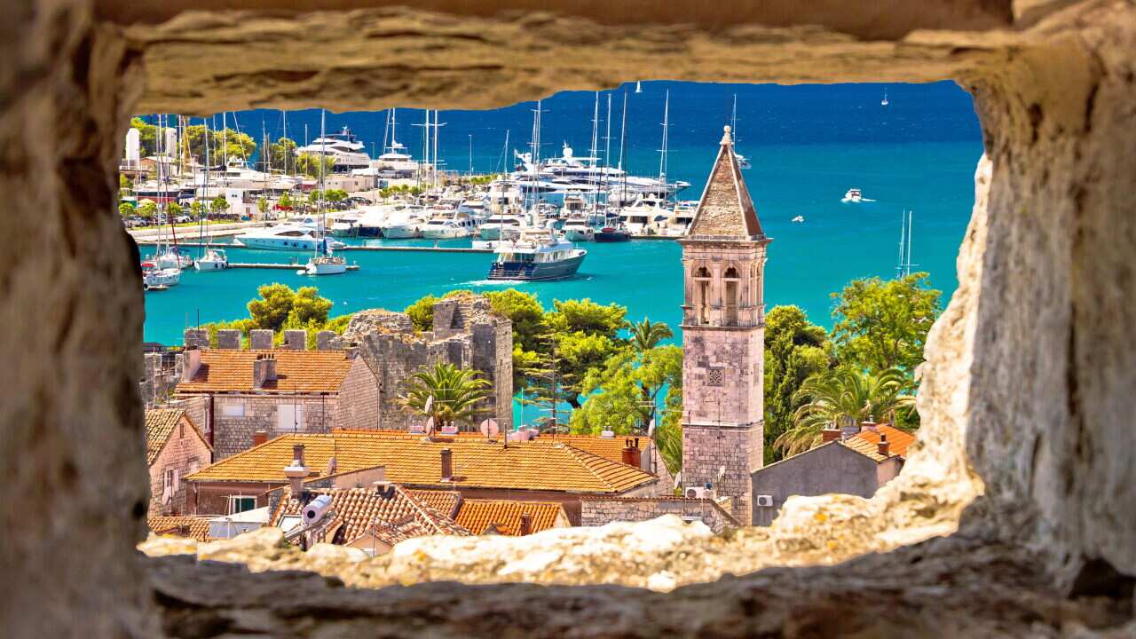 Trogir church and turquoise waterfront view through stone window, Dalmatia region of Croatia