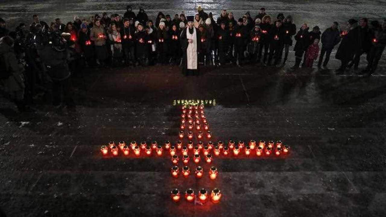 People light candles in front of Christ the Savior Cathedral to commemorate victims of plane crash in Moscow, Russia, 12 February 2018.