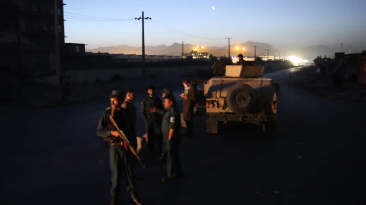 Afghan police block a road leading to the site of an explosion
