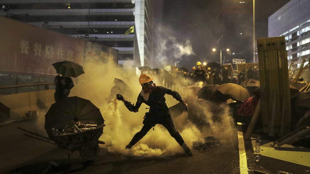 A protester throws a tear gas canister which was fired by riot police during a protest in Hong Kong.