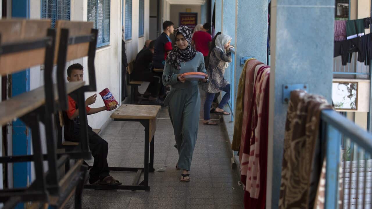 Palestinians take shelter at a school after fleeing Israeli missile strikes in the outskirts of Gaza City