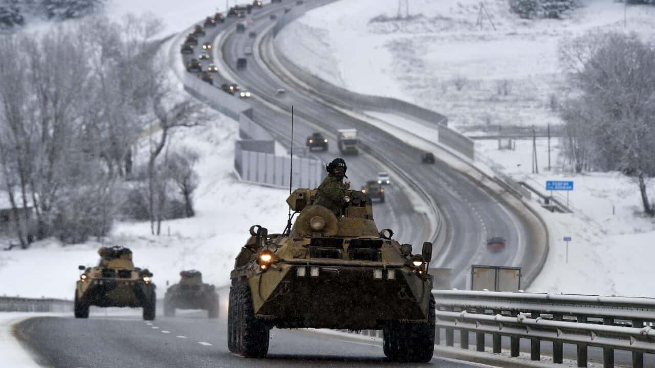 A tank on a road lined by snow