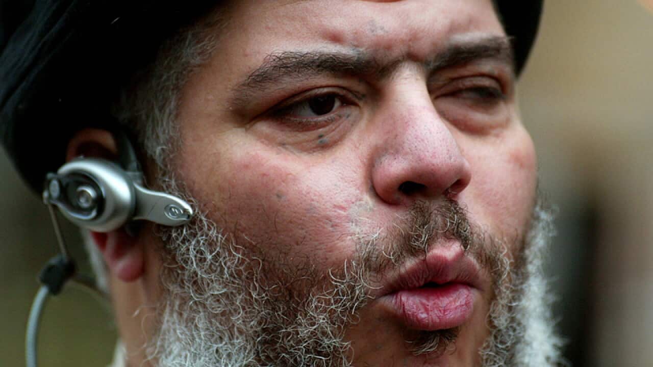 Abu Hamza al-Masri leads his followers in prayer in a street