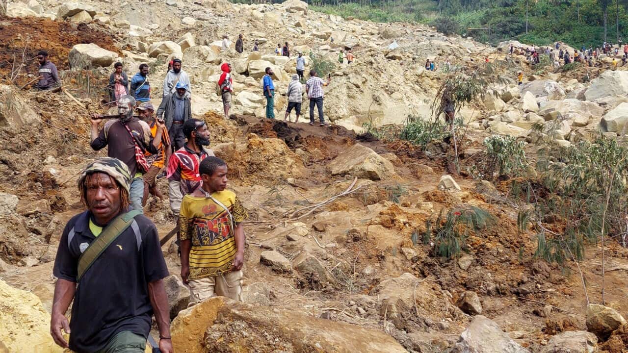Locals gather at the site of a landslide at Mulitaka village.