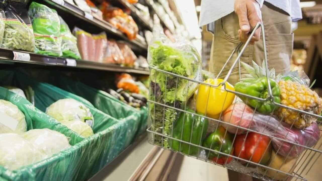Man carrying full shopping basket in grocery store