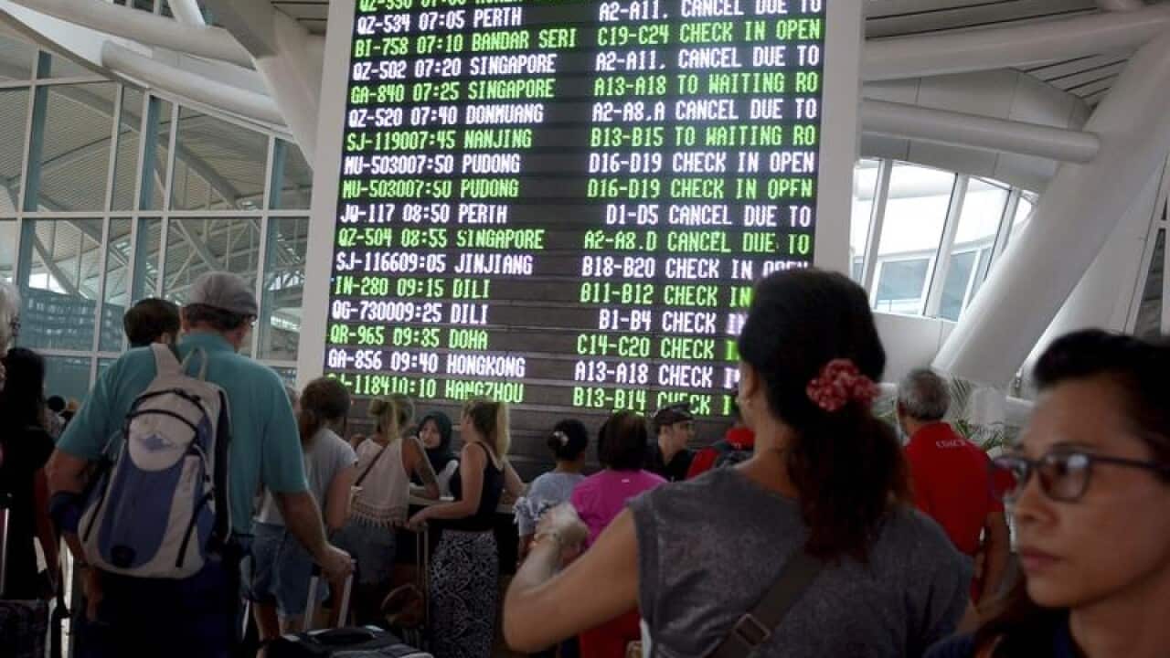 A photo shows a flight information board shows cancelled flights.