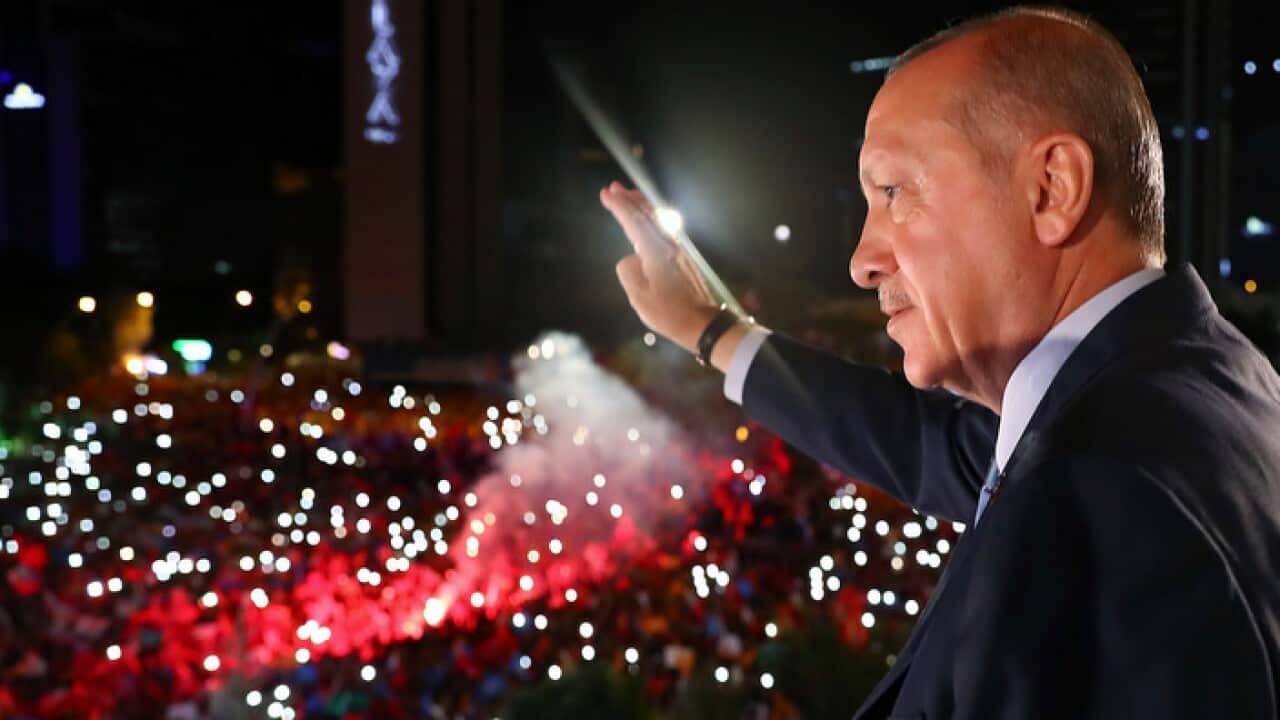 Recep Tayyip Erdogan waves to celebrating supporters