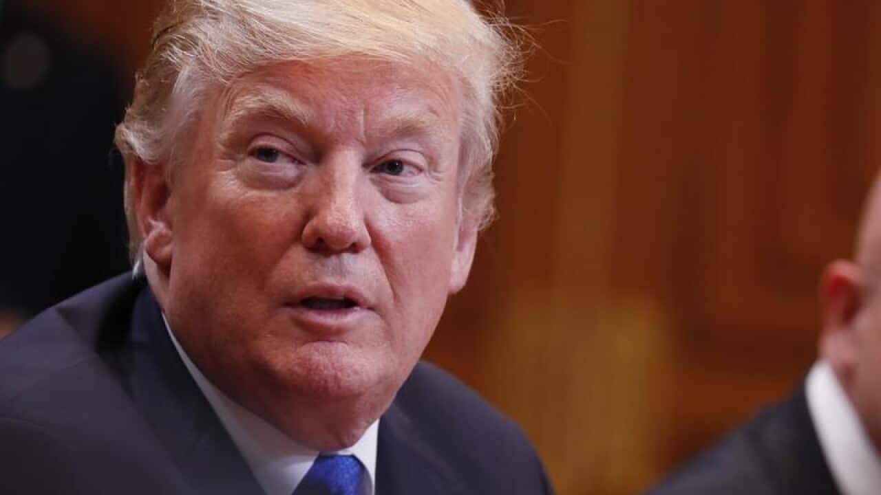 US President Donald J. Trump looks on