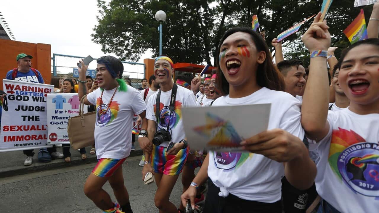 Philippine LGBT members cheer as they march past a group of Christian protesters in the Pride March.