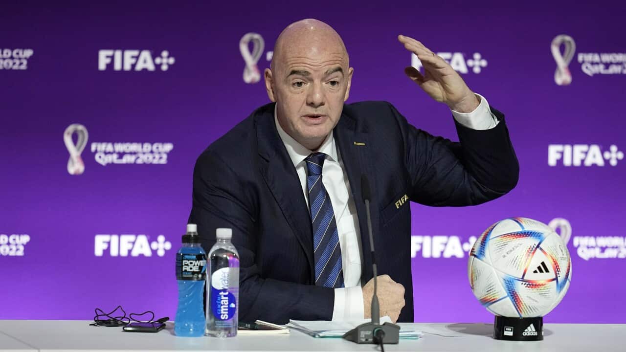 A bald man speaks at a press conference for the 2022FIFA World Cup