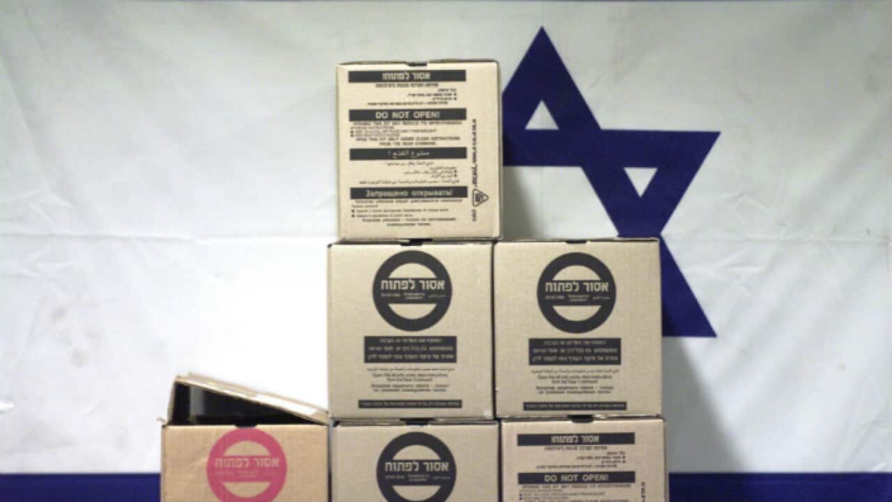 Gas mask boxes in front of an Israeli flag