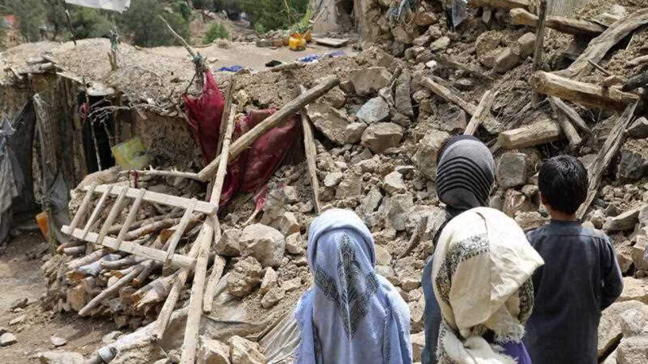 Afghan children stand near a house that was destroyed in an earthquake in the Spera District of the southwestern part of Khost Province, Afghanistan, Wednesday, June 22, 2022.