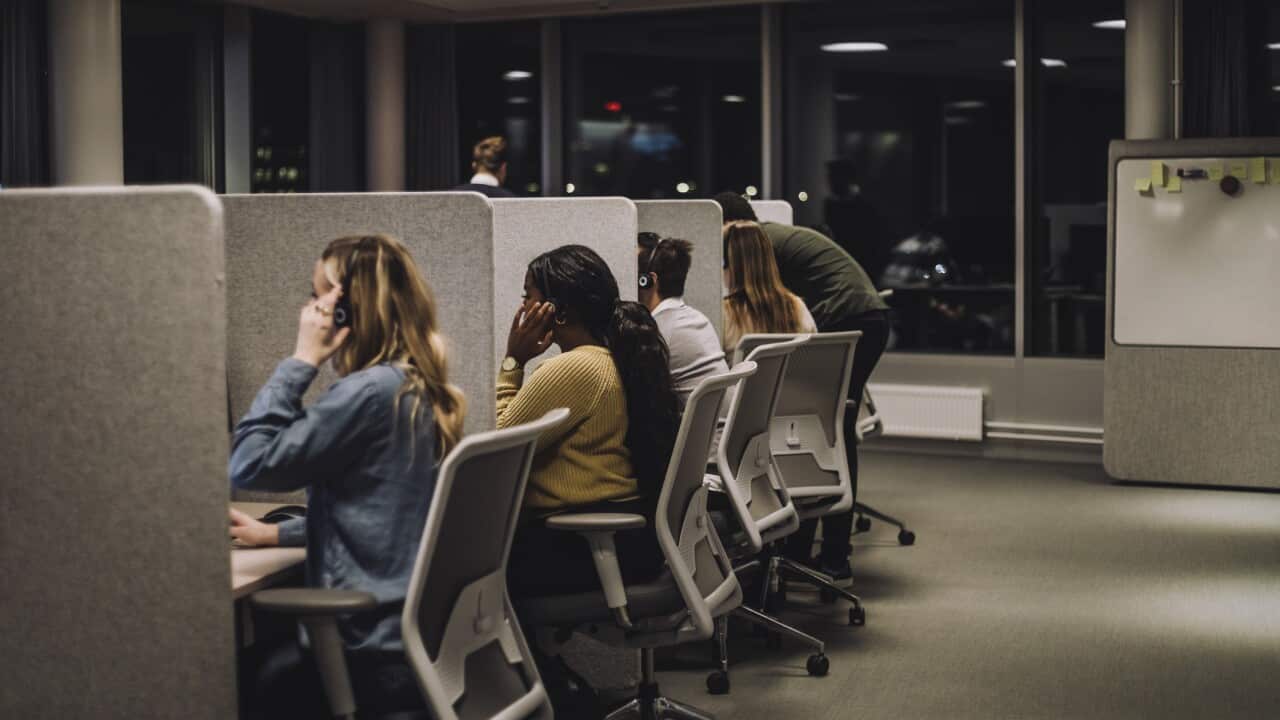 Multiracial team working side by side in illuminated call center