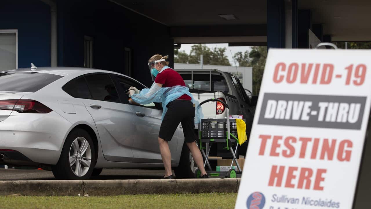 A health worker conducts a COVID-19 test at a drive through facility at Woree in Cairns, Sunday, August 8, 2021.