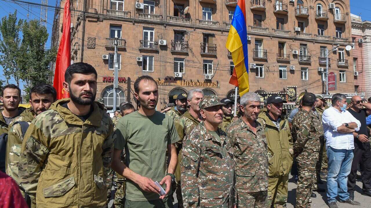 Servicemen and members of the Armenian Revolutionary Federation gather by a statue of Aram Manukyan among volunteers who are to set off for Nagorno-Karabakh.