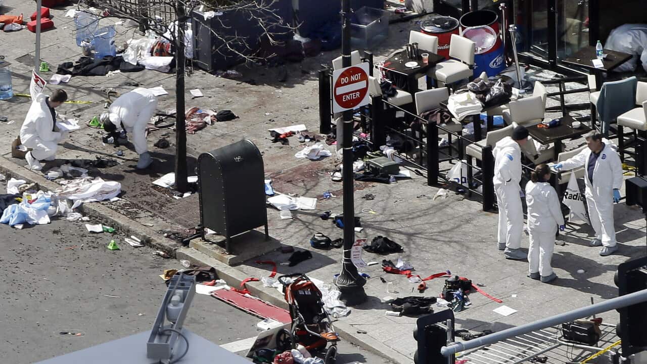 Investigators examine the scene of the second bombing outside the Forum Restaurant on Boylston Street near the finish line of the 2013 Boston Marathon, a day after two blasts killed three and injured more than 260 people. (AP Photo/Elise Amendola, File)