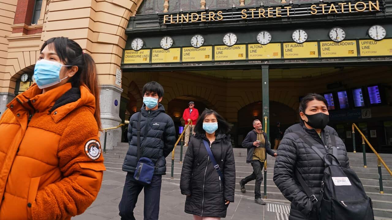 People leave Flinders Street Station while while wearing face masks (AAP).