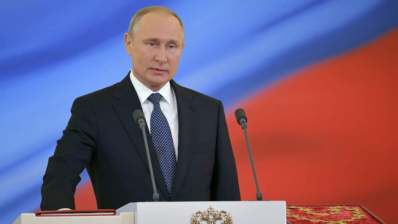 Vladimir Putin speaks with his hand on the Constitution during his inauguration ceremony.