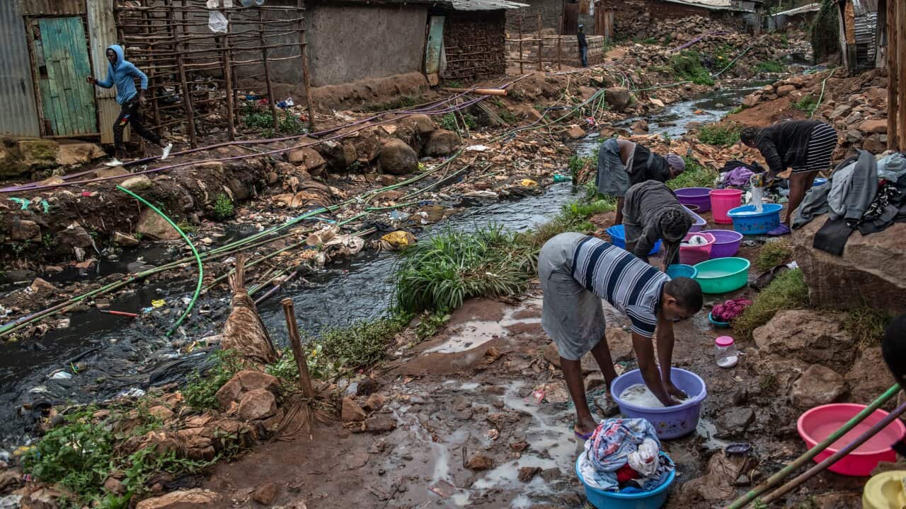 Women wash clothes outside a river polluted with sewage and waste in Nairobi, Kenya. The rate of drug-resistant infections in the community is high.