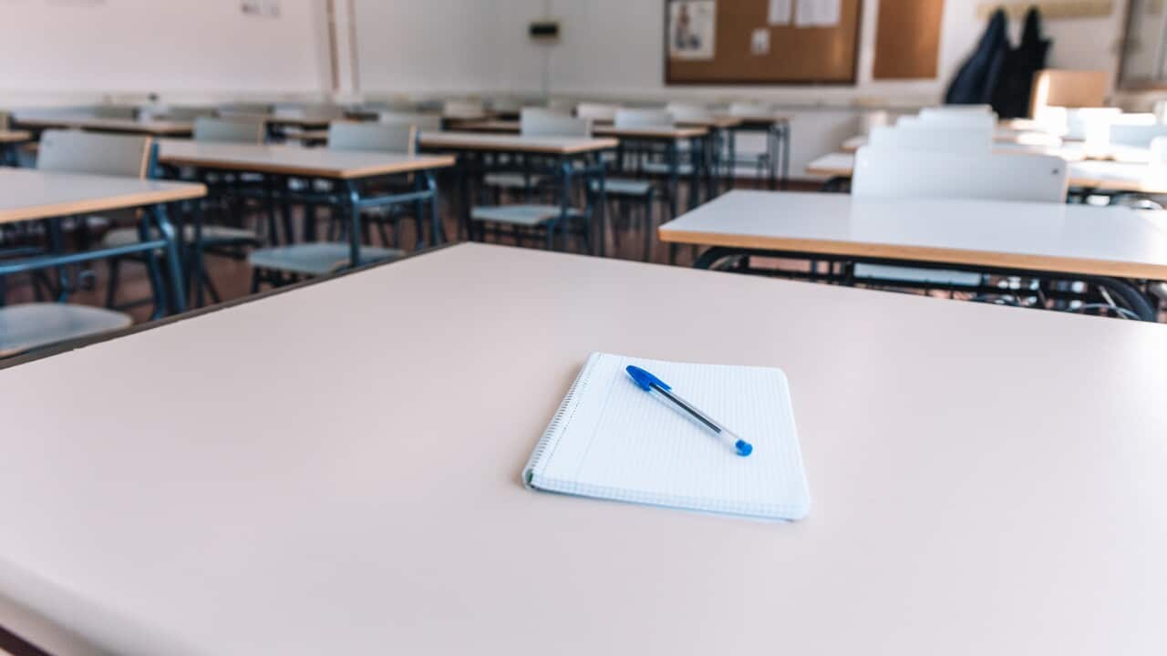 Notebook with a pen on a table in a classroom at a school