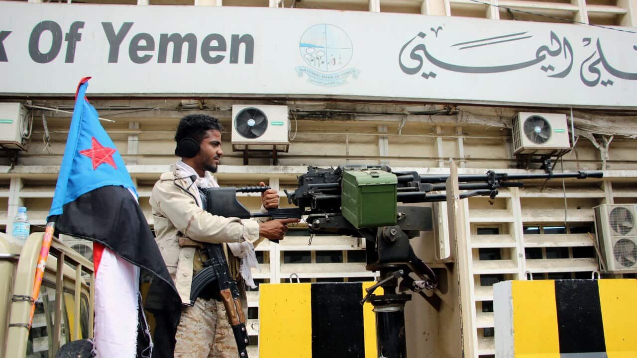 An armed member of the separatist Southern Movement mans a heavy caliber machine gun outside a government building in Aden