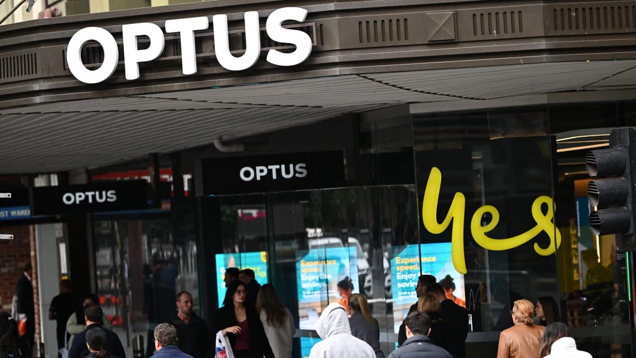 People walking infrot of an Optus store in Melbourne