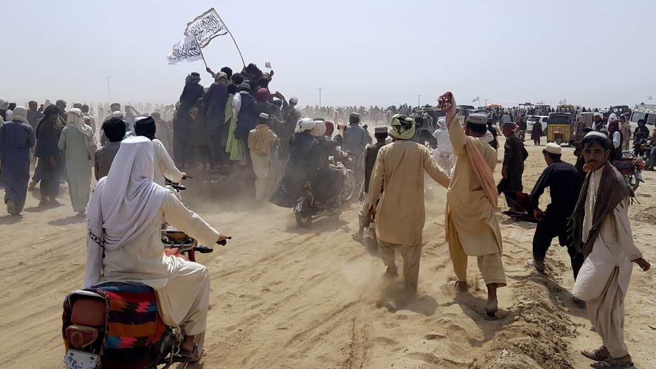 Supporters of Taliban carry the Taliban's signature white flags and drive through the Pakistani border town of Chaman, Pakistan.