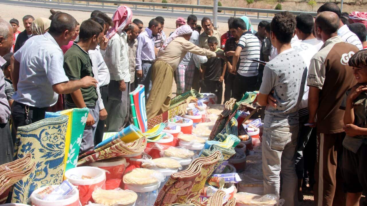 Members of the Yazidi religious minority who fled from violence in Mosul receive humanitarian aid near Dohuk city, northern Iraq (AAP)
