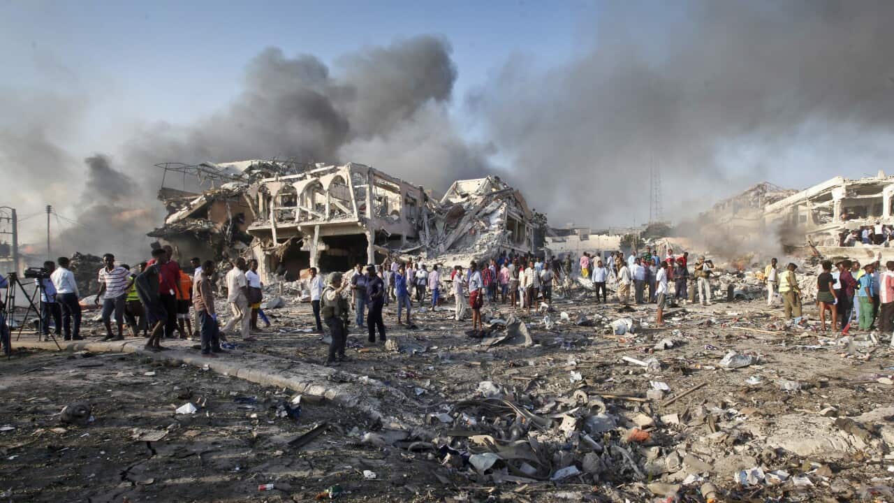 Somalis search for survivors by destroyed buildings at the scene of a blast in Mogadishu, Somalia.