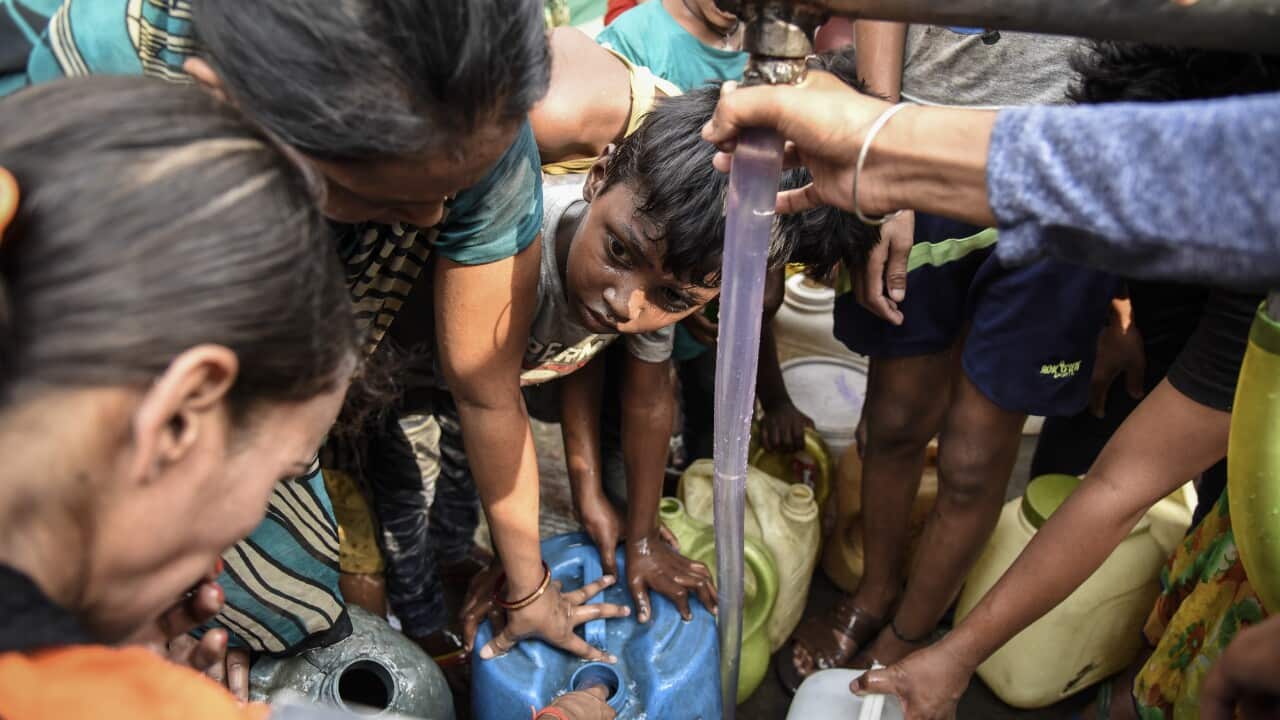 A hose from a water tanker is used to fill containers in the Wazirpur neighborhood of New Delhi, India.