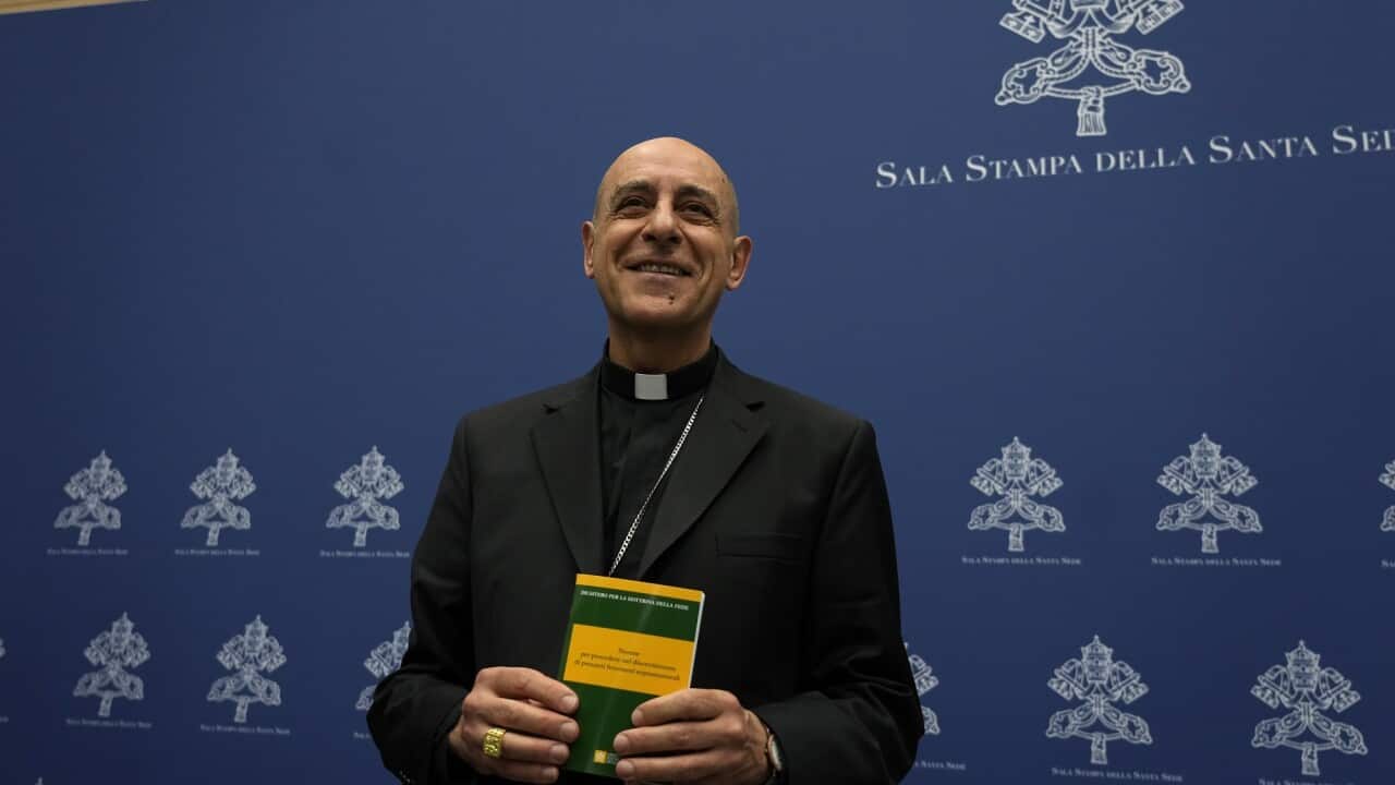 The head of the Vatican doctrine office, Cardinal Víctor Manuel Fernandez, holds the new document with updated guidelines.