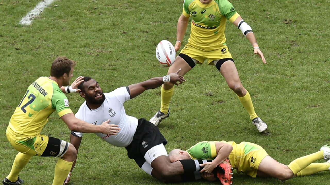 Fiji's Leone Nakarawa (C) is tackled by the Australian defence