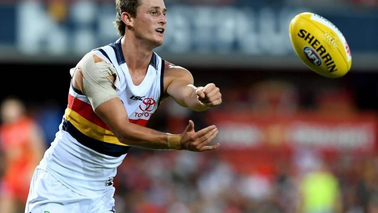Crows player Matt Crouch handballs during Round 5.
