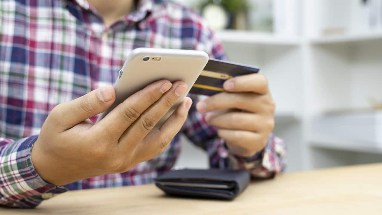 Young man hands holding credit card and using phone