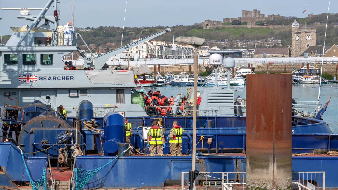 Migrants escorted by Border Force officers after crossing the English Channel in Dover, Britain