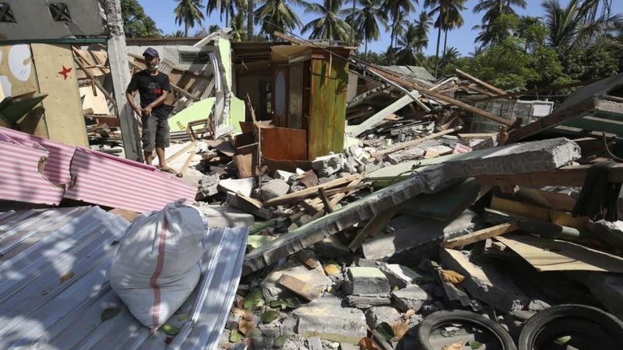 A man walks around his house damaged in the Lombok quake