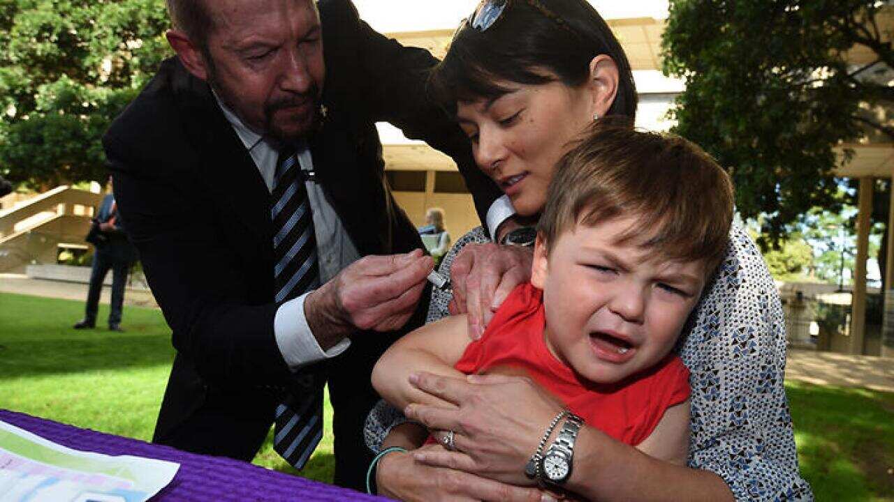 Dr Richard Kidd vaccinates 3 year-old Patrick Cary at Parliament House in Brisbane, Wednesday, Aug. 26, 2015.