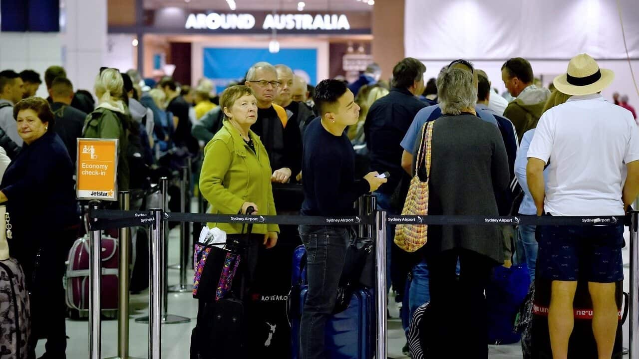 Passengers queue up at the international terminal in Sydney Airport.