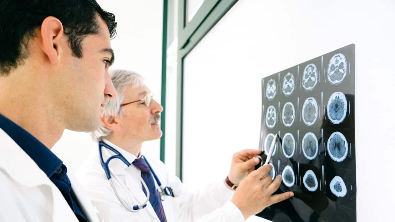 Doctors Consult Over An MRI Scan Of The Brain