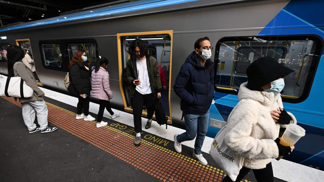 People exiting a train carriage. Others are waiting to enter.