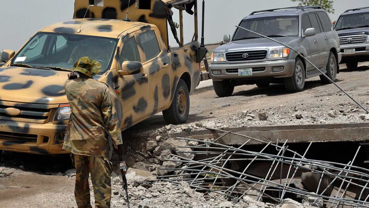 A soldier directs the way to a military truck at Ngala