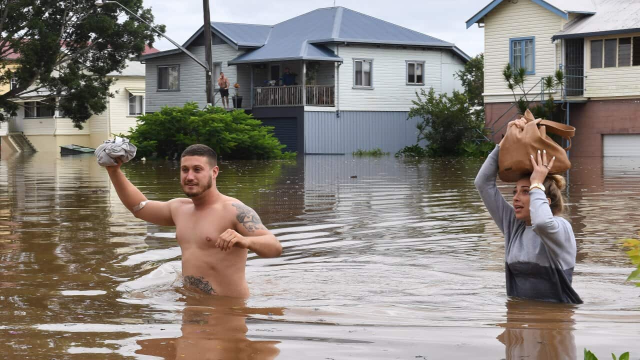 Residents wade through rising floodwaters in Lismore