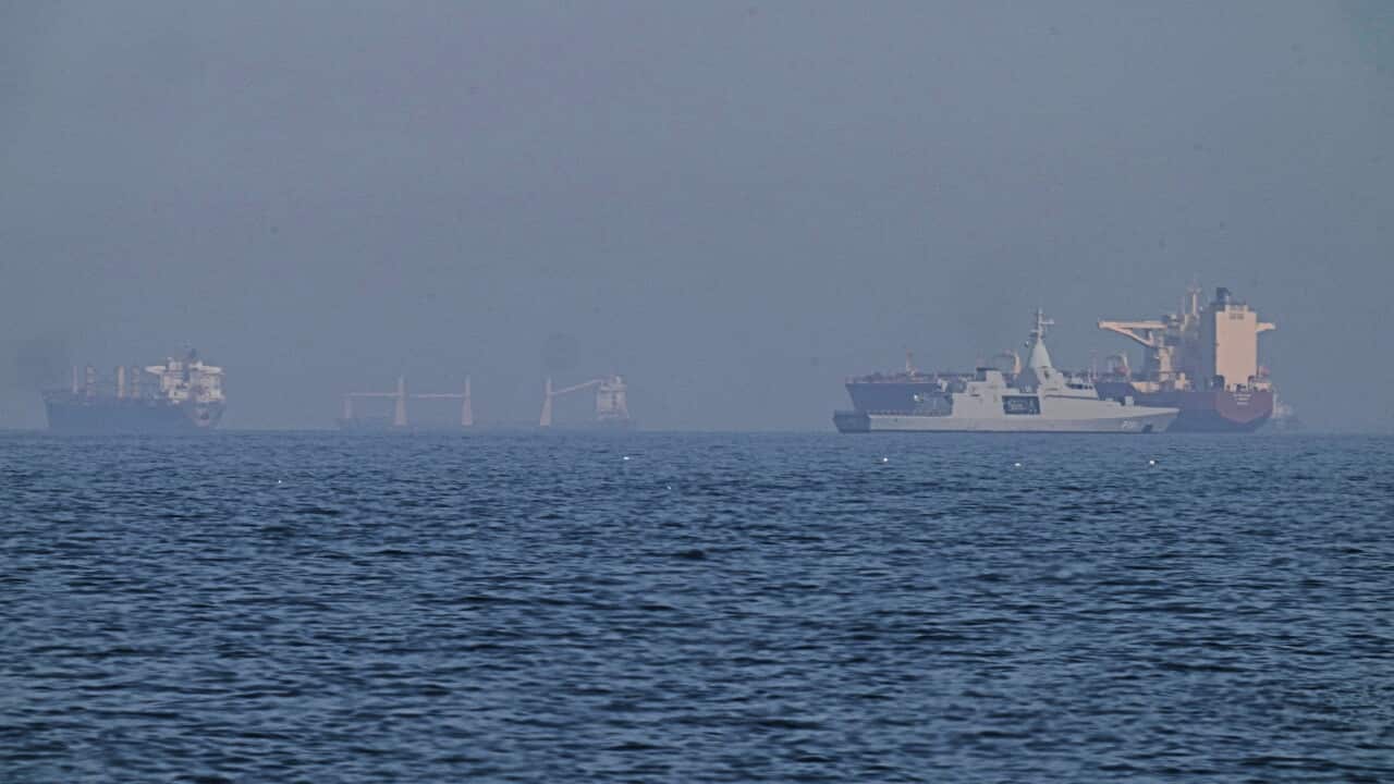 Various cargo ships anchored on a large body of water