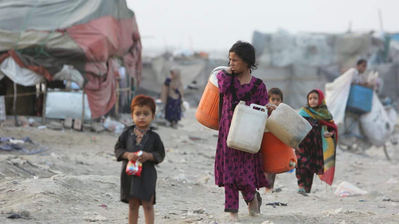 Afghan refugees who fled their homeland due to war and famine, on their way to collect clean water in slums of Lahore, Pakistan.