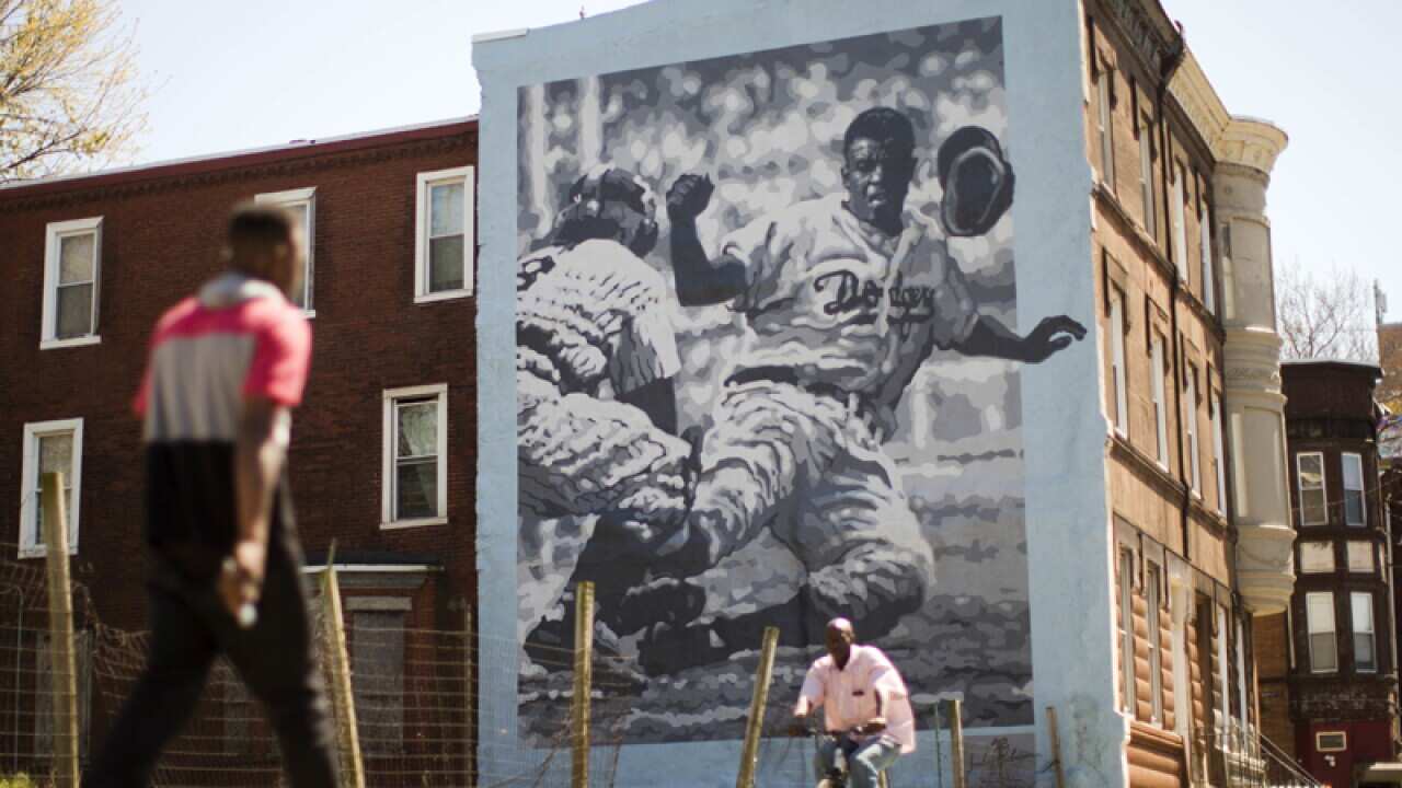 People pass by a mural of Jackie Robinson in Philadelphia