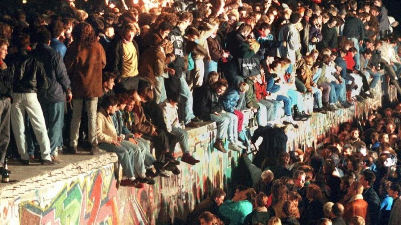 Celebrating the opening of the border between East and West Germany on the Berlin Wall in Berlin,Germany.