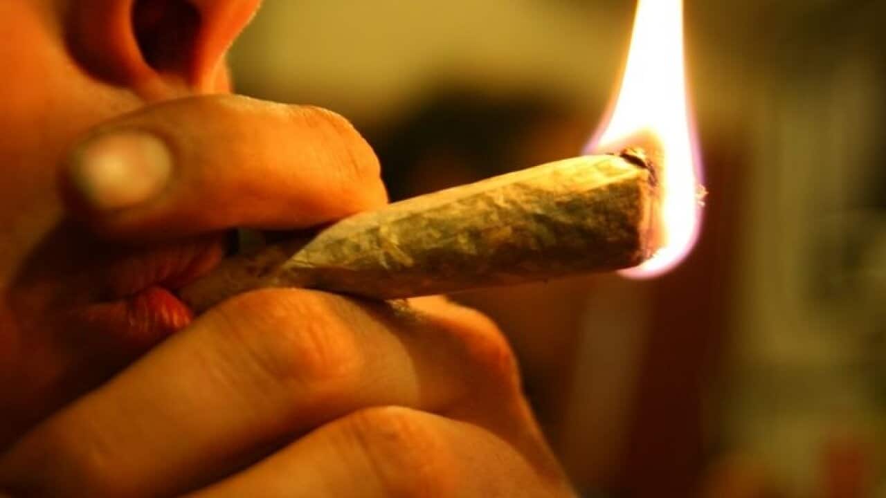 An up close image of a person smoking marijuana