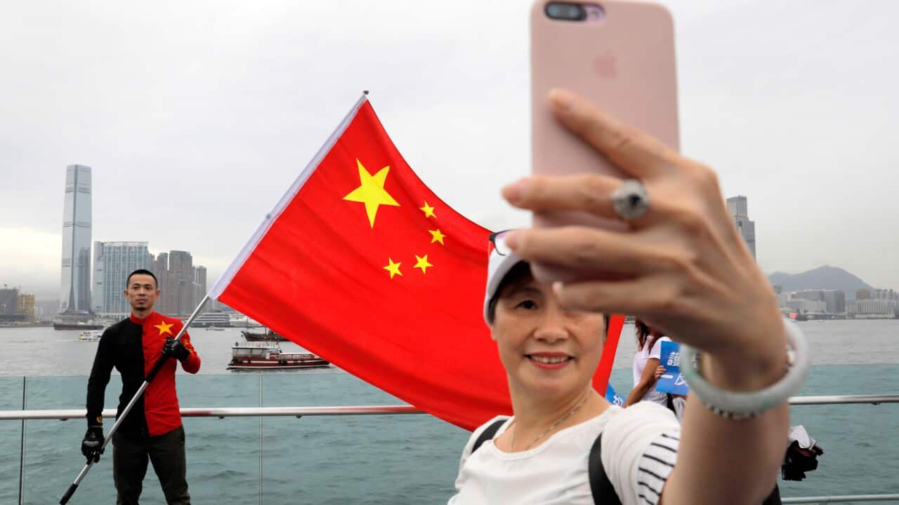 Pro-China supporters take a selfie with a Chinese national flag during a rally at a park in Hong Kong